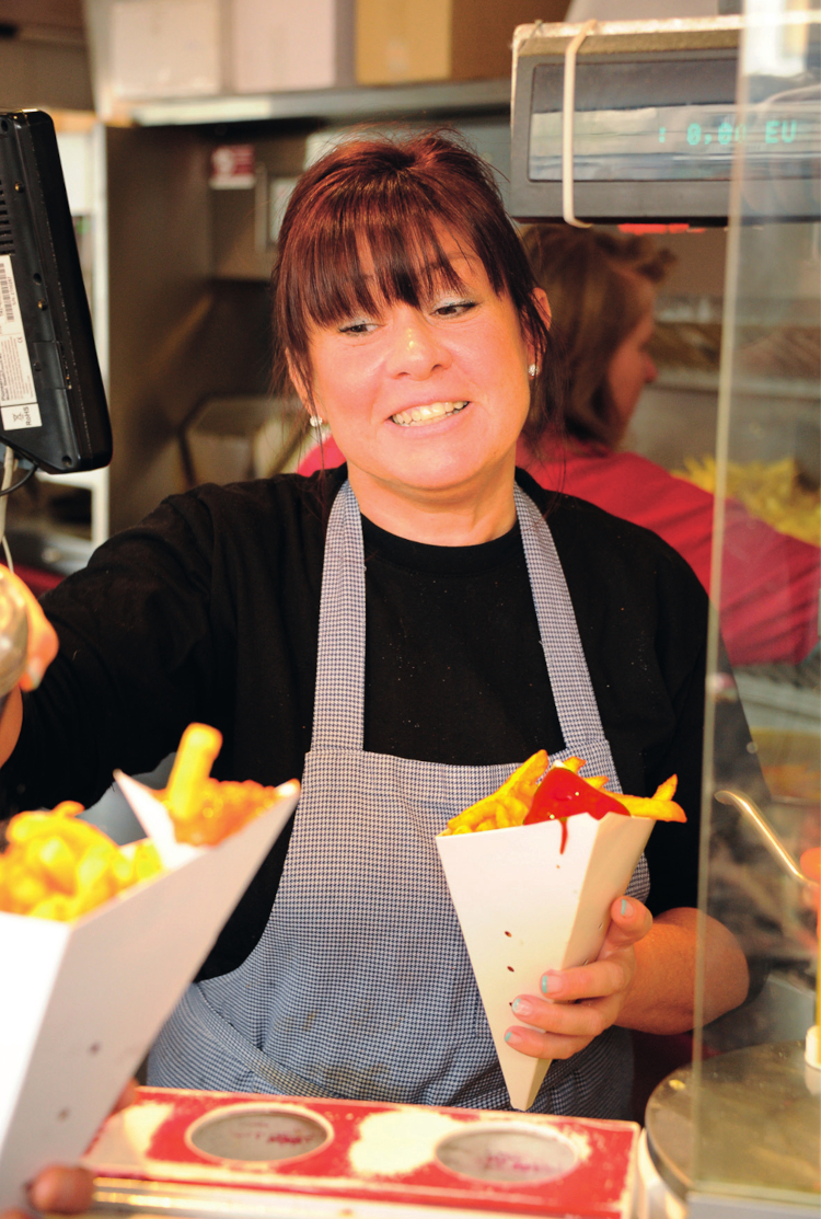 Vendeuse de frites avec un cornet en main