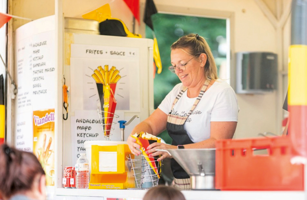 Une autre vendeuse de frites remplissant un cornet